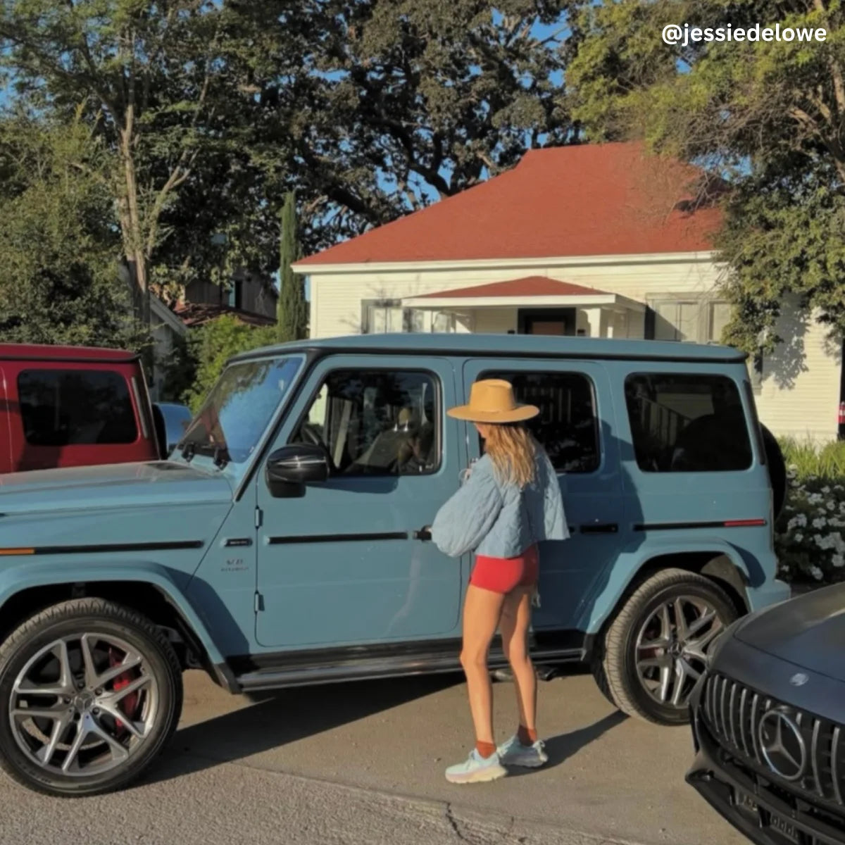 Woman getting into a blue Mercedes-Benz G-Class in a residential area