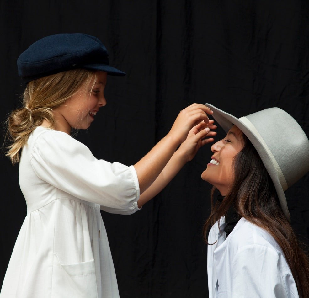 Daughter looking at her mother's grey urban wool felt hat 
