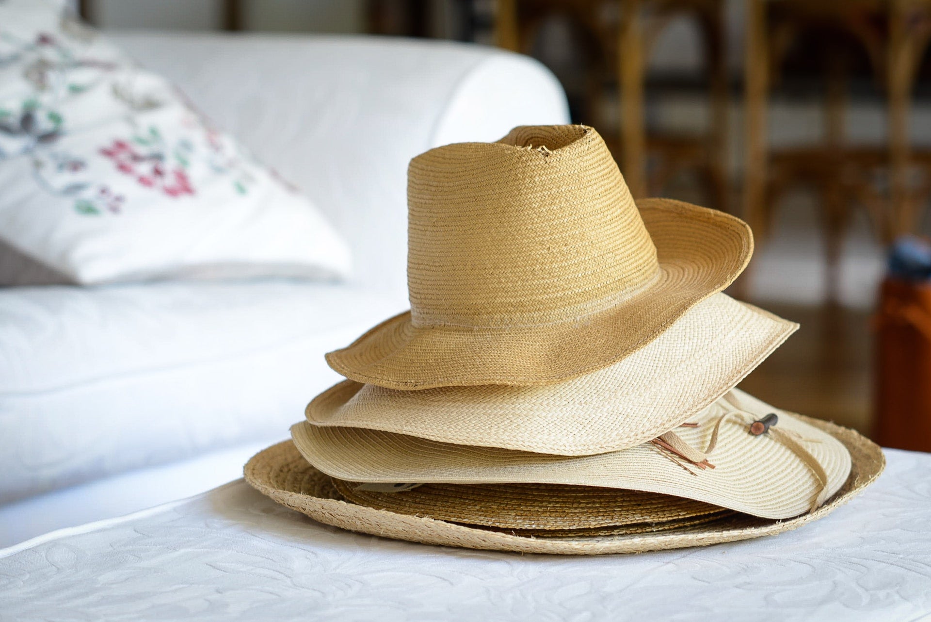 a pile of straw hats of all different styles and designs 